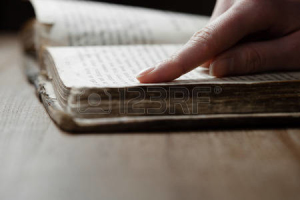 41205312-donna-dito-preme-sul-vecchio-libro-bibbia-in-un-solo-accettabile-scuro-sul-tavolo-di-legno-e-la-lett